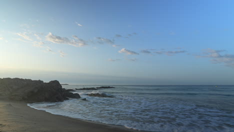 presenciar el impresionante video de la costa del mar mientras las olas ruedan graciosamente en la costa durante las primeras horas de la mañana