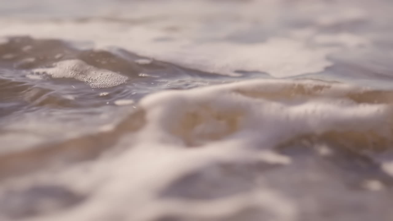 일몰 동안 해변에서 돌진하는 바다 파도