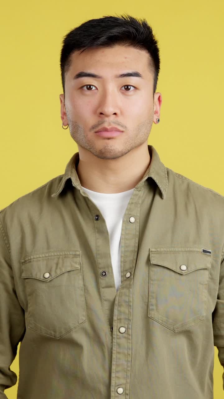 Portrait of a man with arms crossed against yellow background