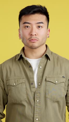 portrait of a man with arms crossed against yellow background