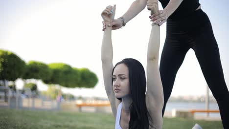 two sporty girls working out together outdoors doing fitness two sporty girls working out together outdoors doing fitness aerobics and stretching exercises in the park morning exercise