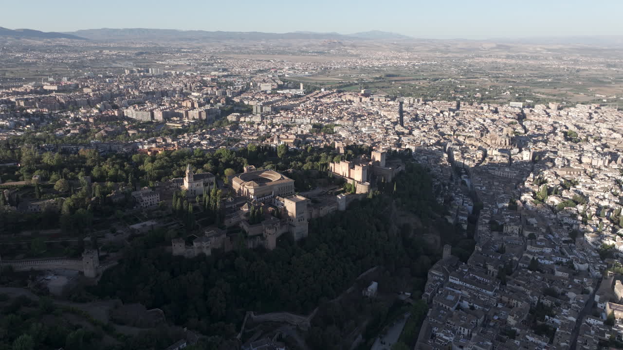 Ampia veduta aerea con drone di Granada e del palazzo fortezza dell'Alhambra in Andalusia, Spagna, Europa, all'alba. Architettura nasride islamica e rinascimentale spagnola. Drone in orbita. Ripresa in ProRes 422 HQ