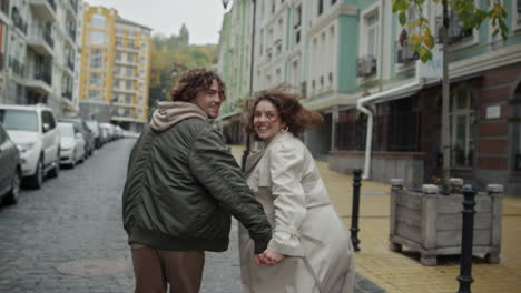 una pareja feliz corriendo por la ciudad vieja.