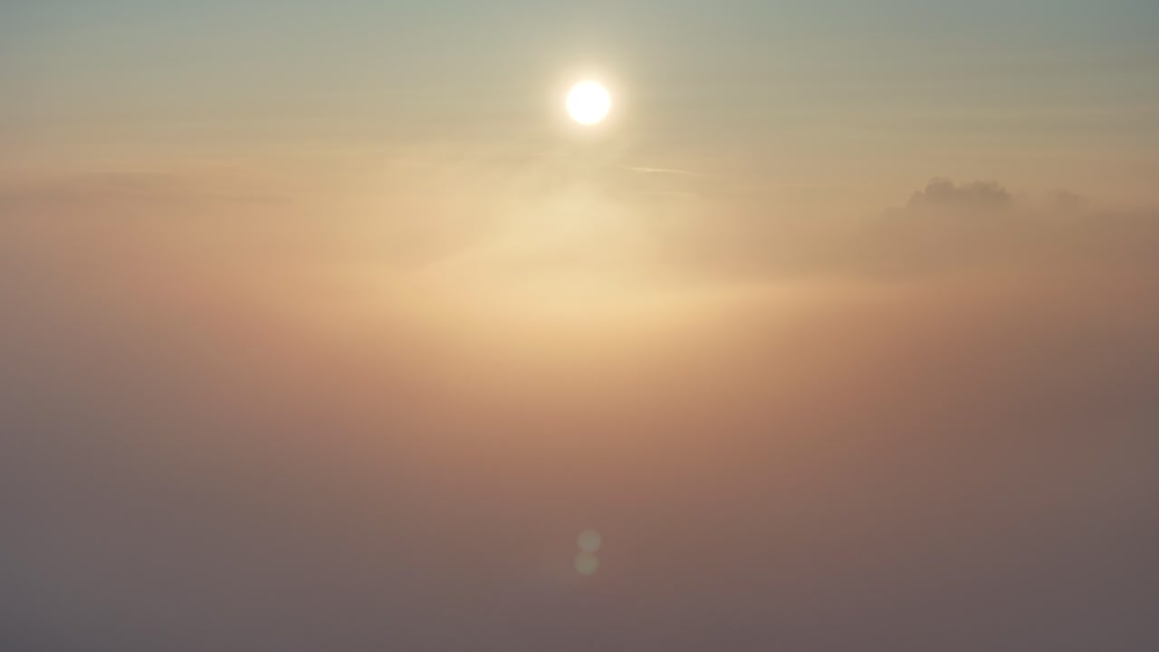 vista del amanecer del avión no tripulado panorámica de izquierda a derecha por encima de la niebla dorada de invierno