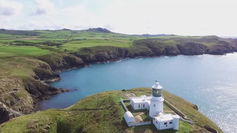 Lighthouse-High-on-Headland-Island-with-Blue-Sea-Beneath