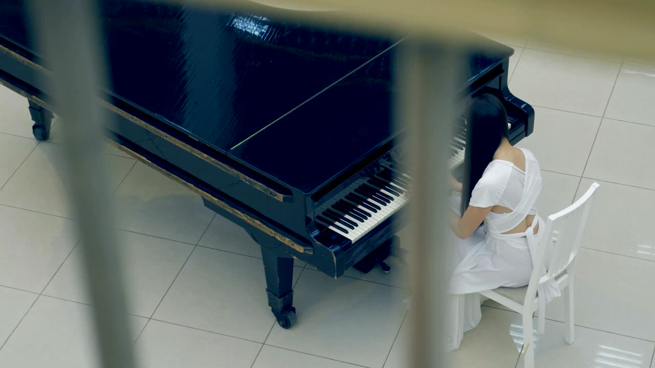 Ripresa dall'alto di una ragazza che suona il pianoforte. Senza volto. 4K