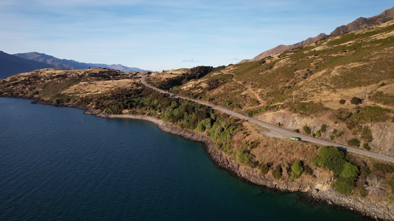 Mountain Pass And Lake Hawea On A Sunny Day In South Island, New Zealand. - aerial pullback shot