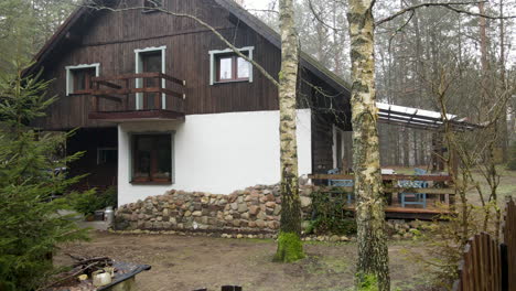 beautiful wooden cabin surrounded with trees on a misty morning in bartoszylas, poland