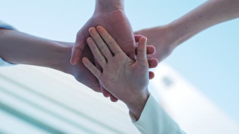 five people lay their hands on each other as sign of business connection and cohesion, concept end of a successful year