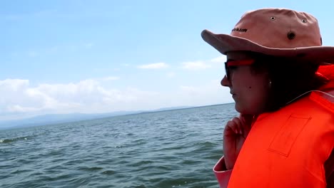 close-up of a woman wearing an orange lifejacket on a guided tour across lake naivasha