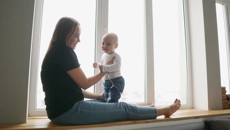 Baby-Junge-9-Monate,-Blick-In-Die-Kamera.-Mit-Sonnenflair,-Gehalten-Von-Mama.