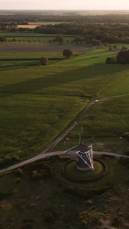 aerial view of a windmill and farmlands at sunset