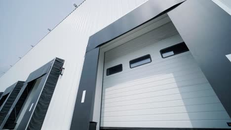 there are automatic gates at a large warehouse. the gates are used for loading cargo from large trucks.