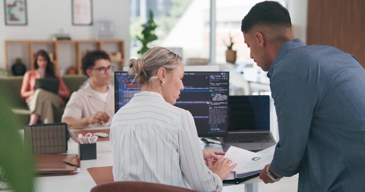 Colleagues Collaborating on Business Documents in Modern Office