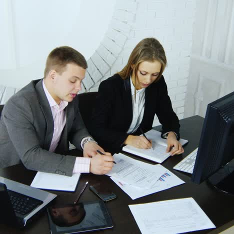 director discusses with secretary projects at table