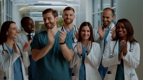 diverse group of medical professionals clapping in a hospital hallway