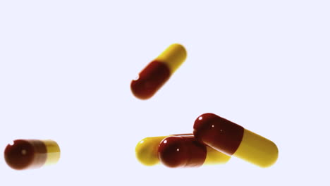 Red-and-yellow-capsule-tablet-falling-and-bouncing-on-others-close-up