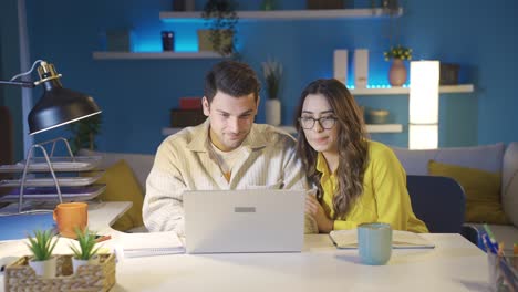 Excited-husband-and-wife-looking-at-laptop-in-hopes-of-good-news.