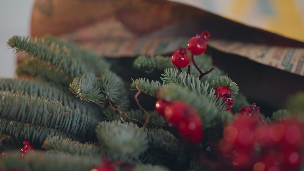 Close-up de ramos de pinheiro e bagas vermelhas para decoração de presente de Natal, inspiração de florista arranjando guirlanda, raminhos perenes texturizados, bokeh de foco raso e contraste de cores festivas para a estação