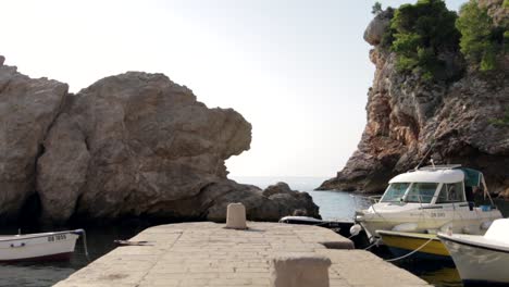 Small-boats-docked-at-a-stone-jetty-in-Croatia,-Dubrovnik