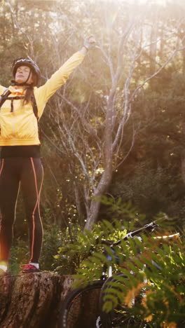 excited female mountain biker with arms outstretched