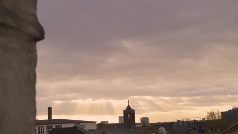 golden hour light shining over a church and rooftops with a plane flying above