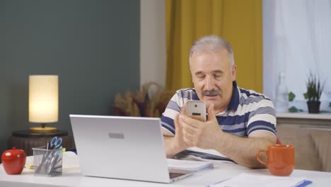 home office worker old man talking on the phone facetime happily.