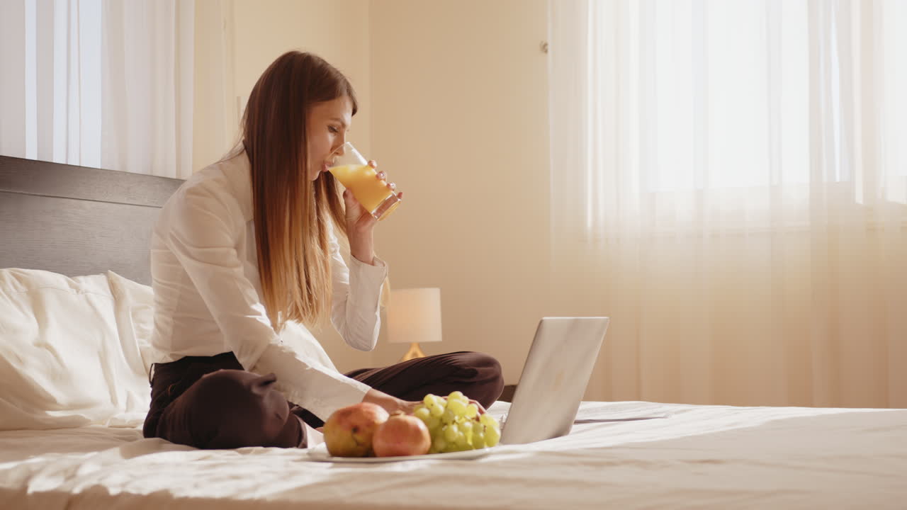 침대에서 집에서 일하는 여자