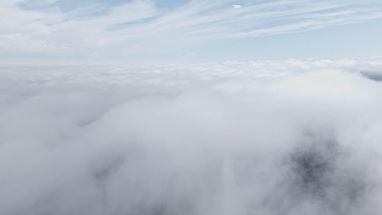 Above dense white clouds during flight, layers of mist and light below sky
