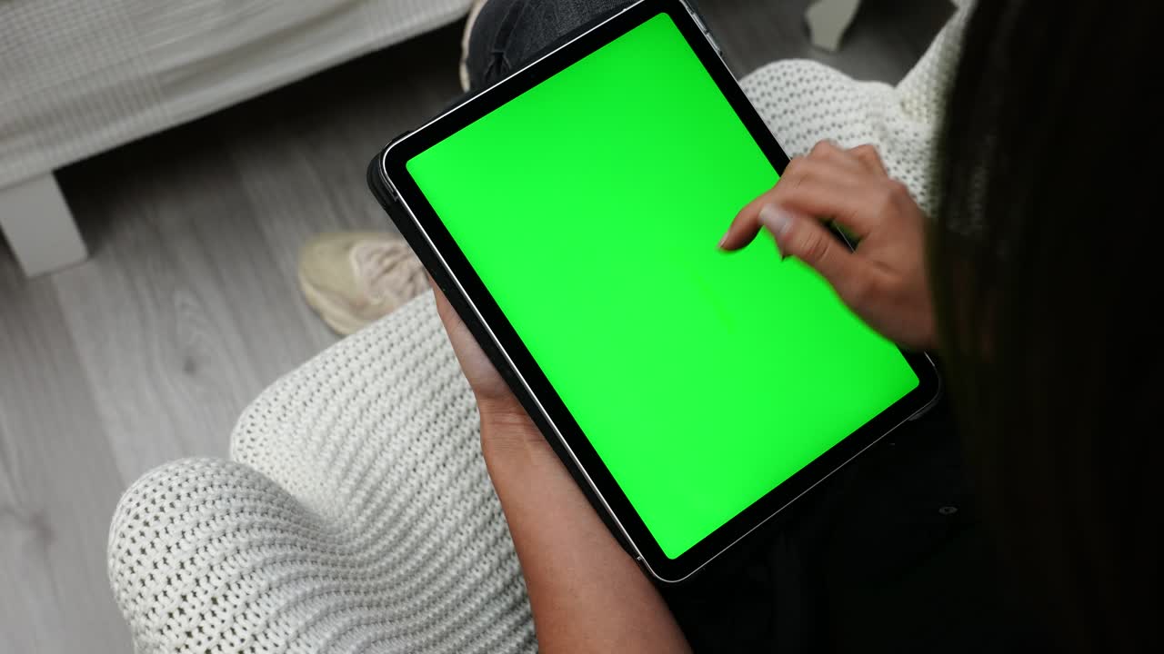 mujer deslizando el dedo en una tableta con pantalla verde, cambiando páginas en línea, de cerca
