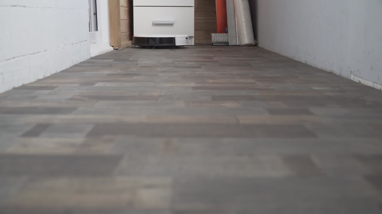 hogar inteligente. la aspiradora robot realiza la limpieza automática del apartamento en un determinado momento. ayudante inteligente en el hogar. un moderno limpiador robótico limpia el polvo en el suelo. tecnología de limpieza