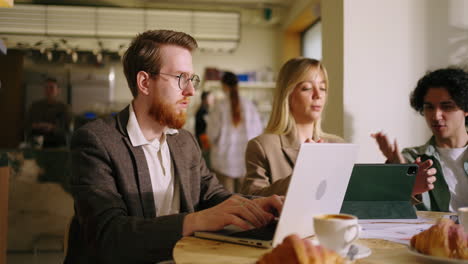 three people working together at a cafe
