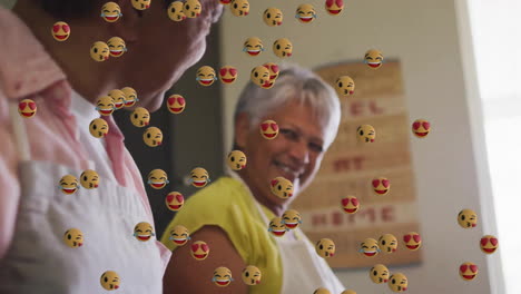 animación de iconos emoji sobre una pareja biracial senior cocinando juntos en la cocina
