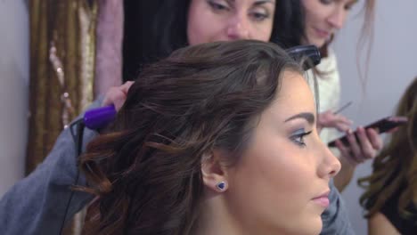 Beautiful-woman-having-her-hair-curled-in-barber-salon