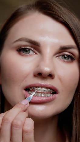 mujer limpiando los dientes con aparatos dentales