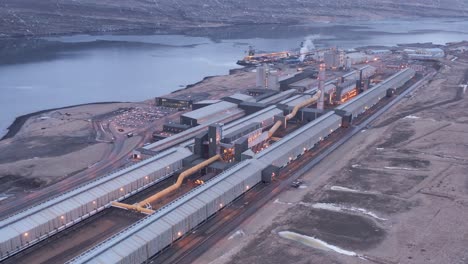 early morning at alcoa fjardaál aluminium factory in iceland, aerial