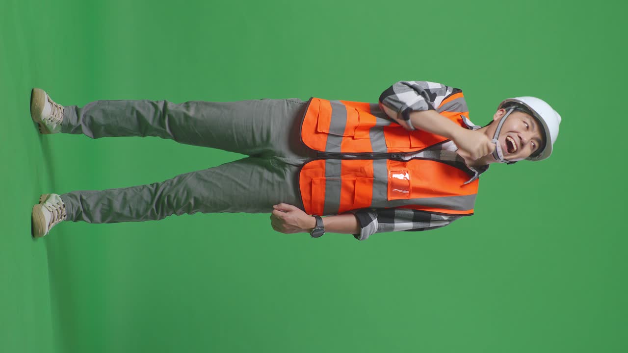 Full Body Of Asian Male Engineer With Safety Helmet Thinking And Looking Around Then Raising His Index Finger While Standing In The Green Screen Background Studio