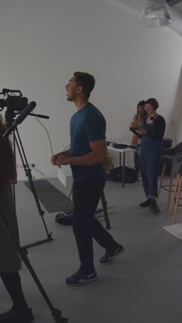 vertical video of actors meeting female director and crew on film set shooting movie or video in studio 2