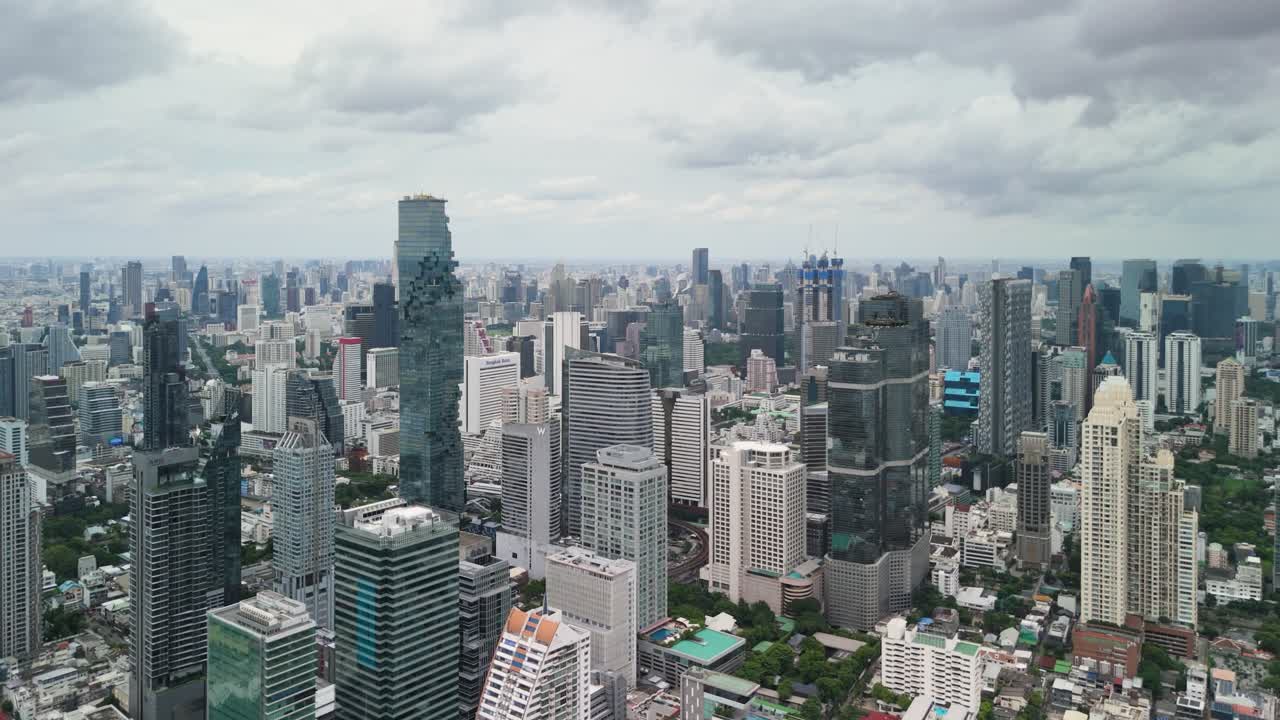 Dramatic aerial view of the Bangkok skyline during the rainy season, covered in thick fog and dark monsoon clouds
