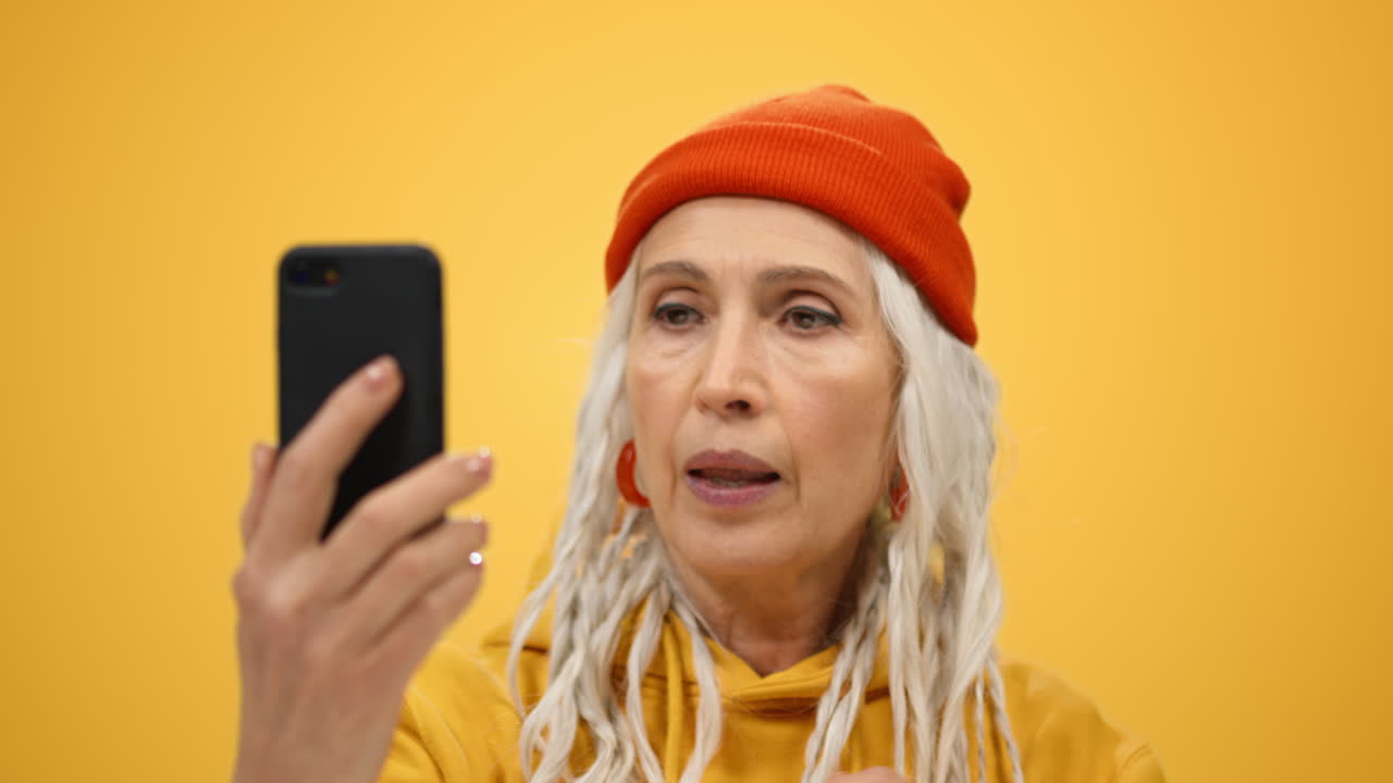 mujer de edad alegre haciendo un gesto de victoria en el interior. mujer mirando la cámara en el interior.
