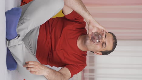 vídeo vertical del hombre que bebe agua a intervalos regulares. el hombre busca la curación.