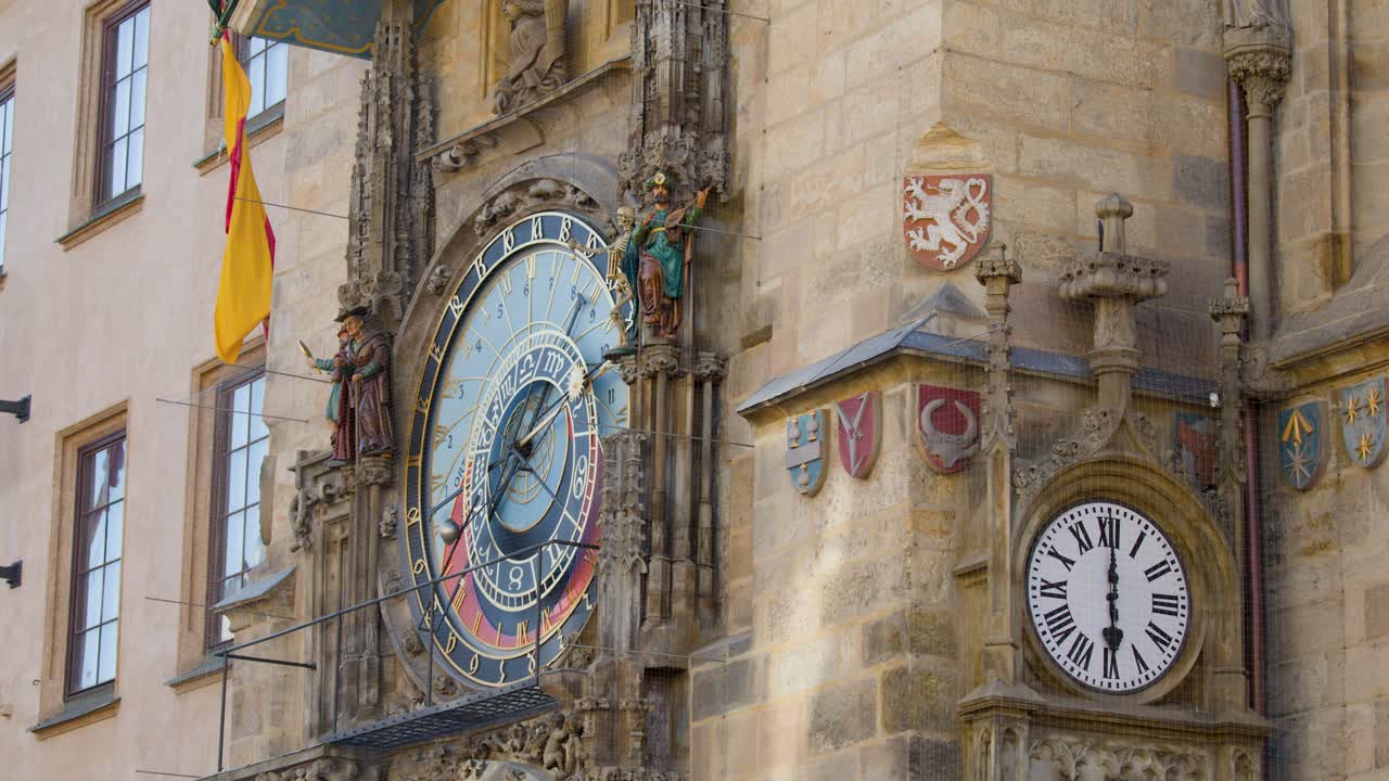 Medieval astronomical clock with rotating statues, ornate details, and natural daylight, slight camera pan