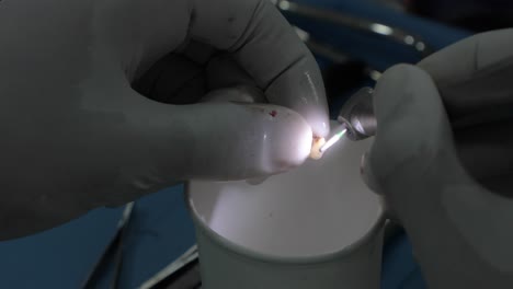 dentista de cultivos que utiliza el taladro dental en la clínica