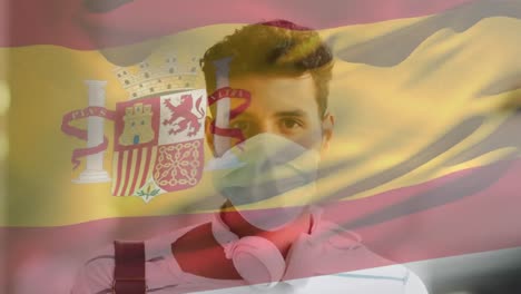 Animation-of-flag-of-spain-waving-over-man-wearing-face-mask-during-covid-19-pandemic