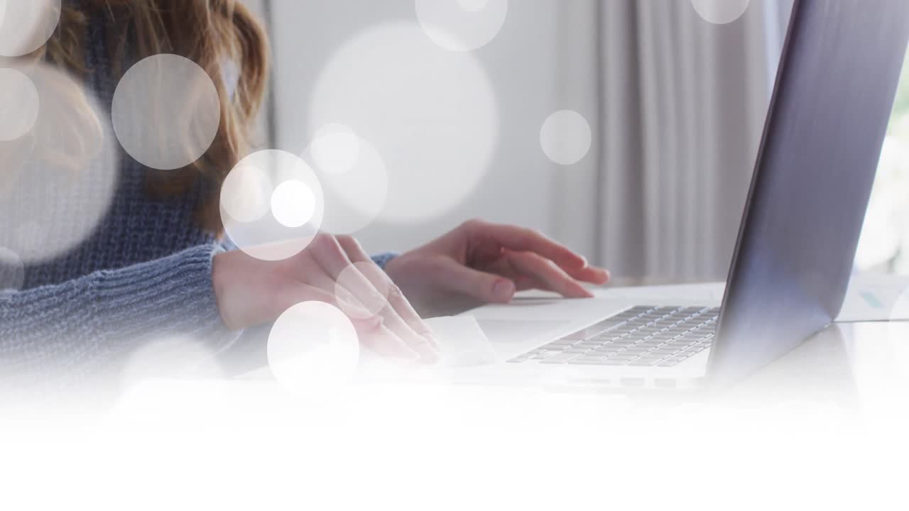 animación de manchas blancas sobre mujer caucásica limpiando portátil en casa.