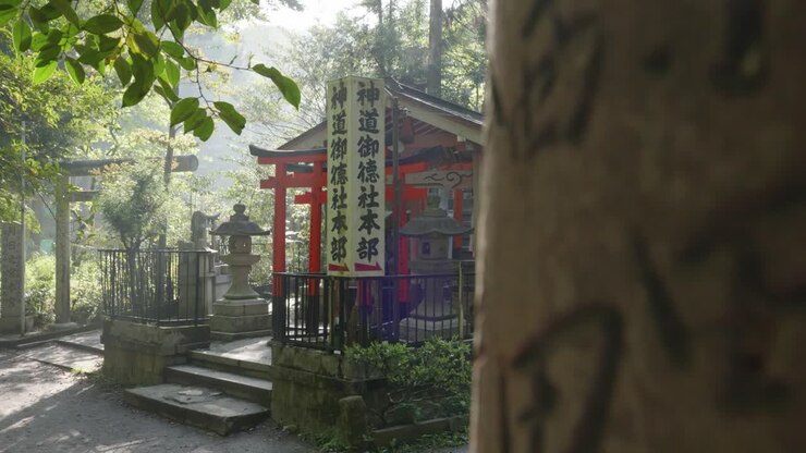 Sole mattutino che splende su un piccolo santuario tradizionale giapponese in una foresta a Fushimi Inari Taisha, Kyoto, Giappone