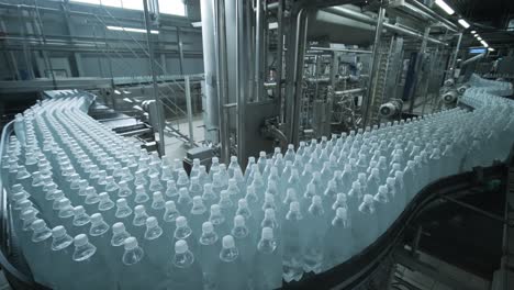 cinta transportadora con botellas de agua potable en una planta de bebidas moderna