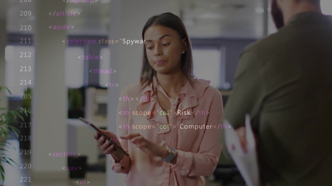 Talking woman in pink blouse holding tablet, gesturing in open office, papers right, code overlay