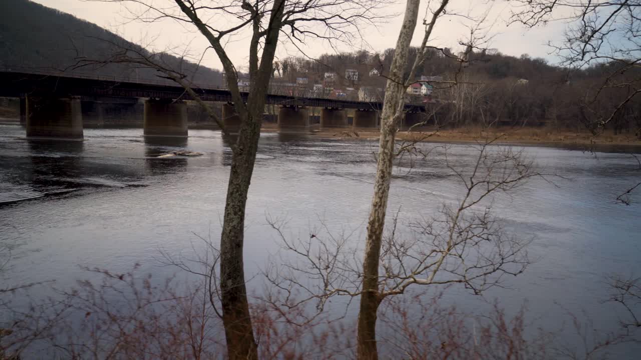 Bridge over a Calm River with Bare Trees
