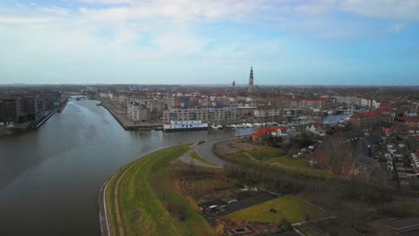 the historical city of middelburg with in the foreground a canal and industrial area